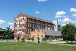 The Footers Dye Works building photographed against a blue sky and green lawn in Cumberland, Maryland.