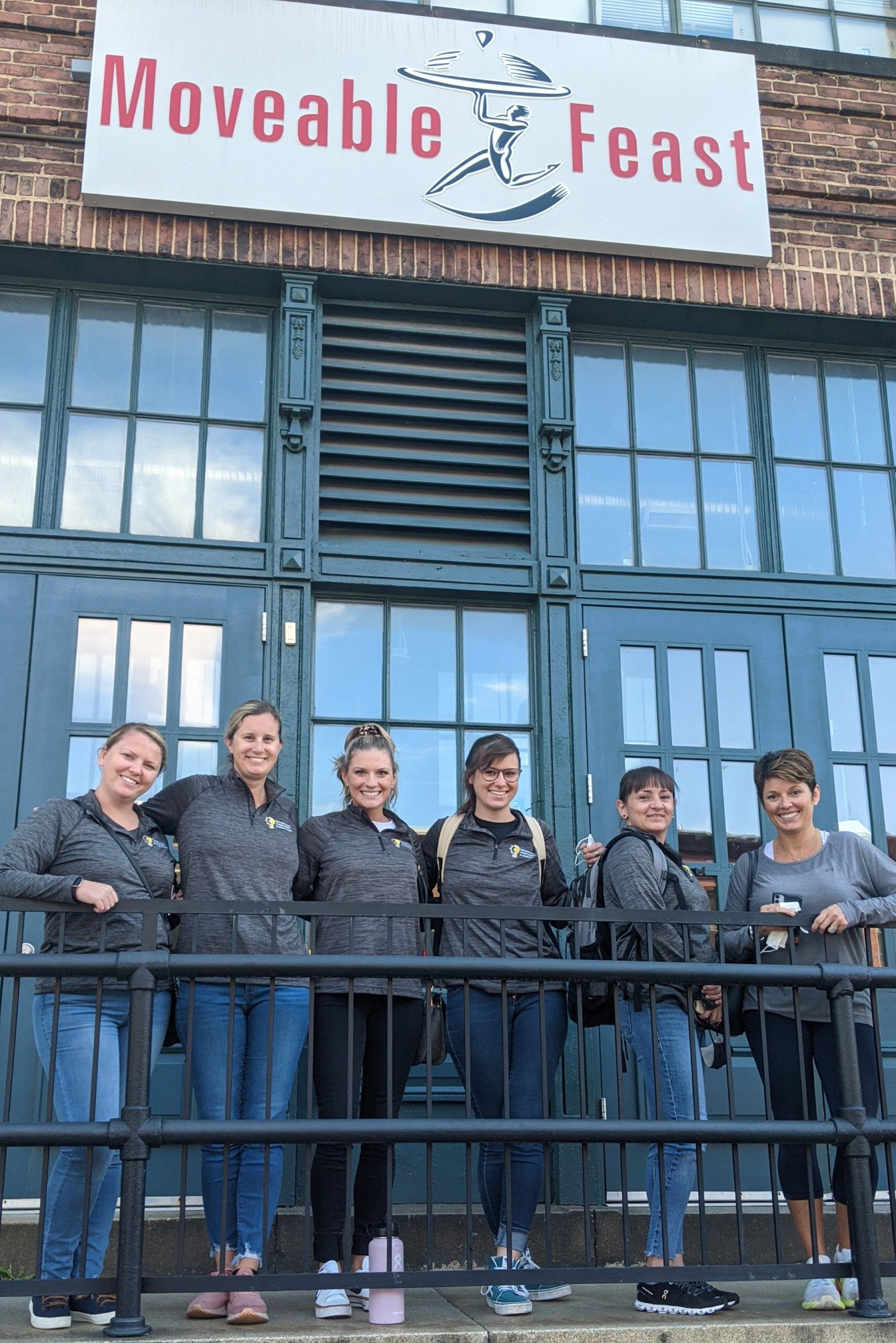 Group of volunteers poses in front of the Moveable Feast building
