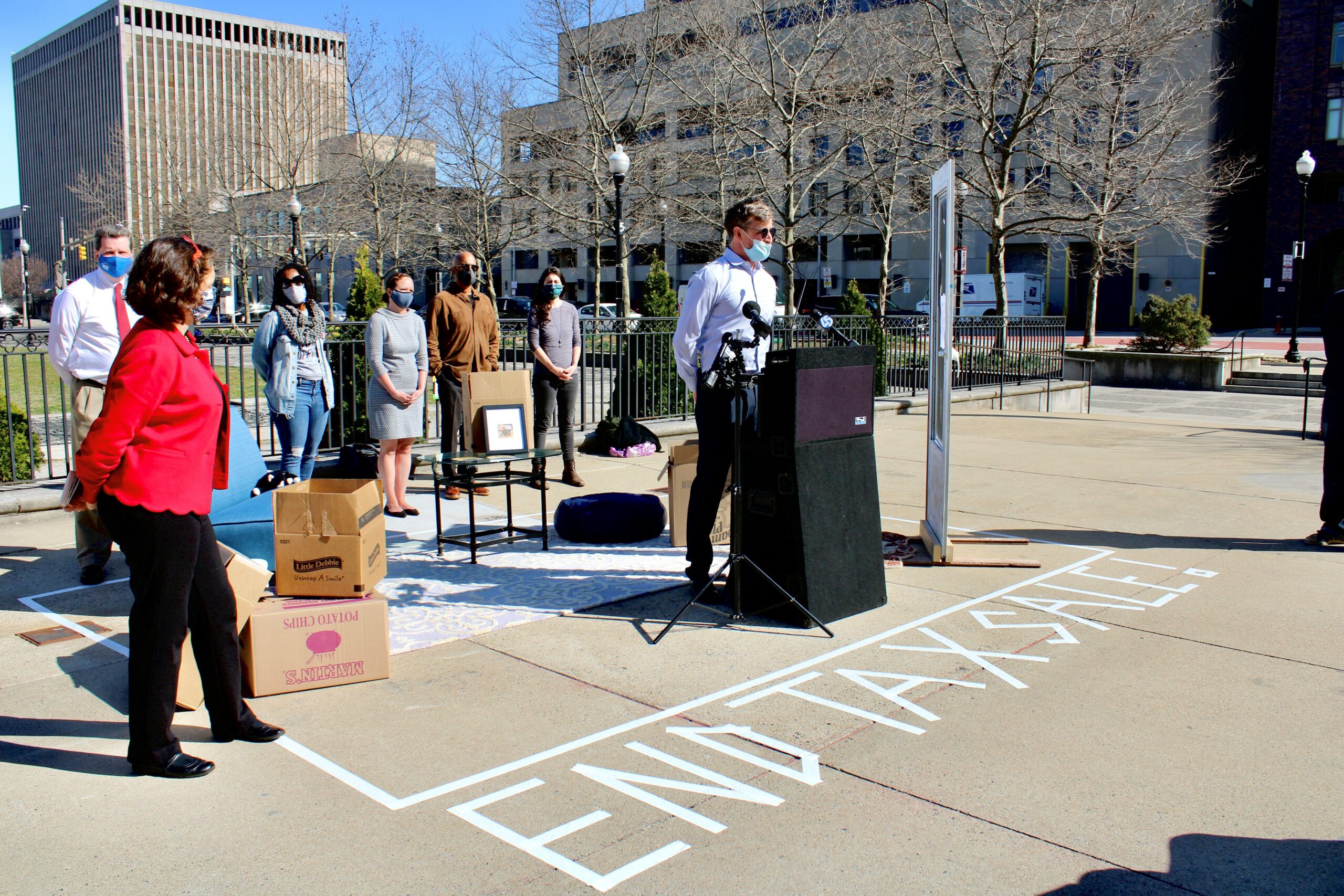 Man stands behind podium outside of City Hall.