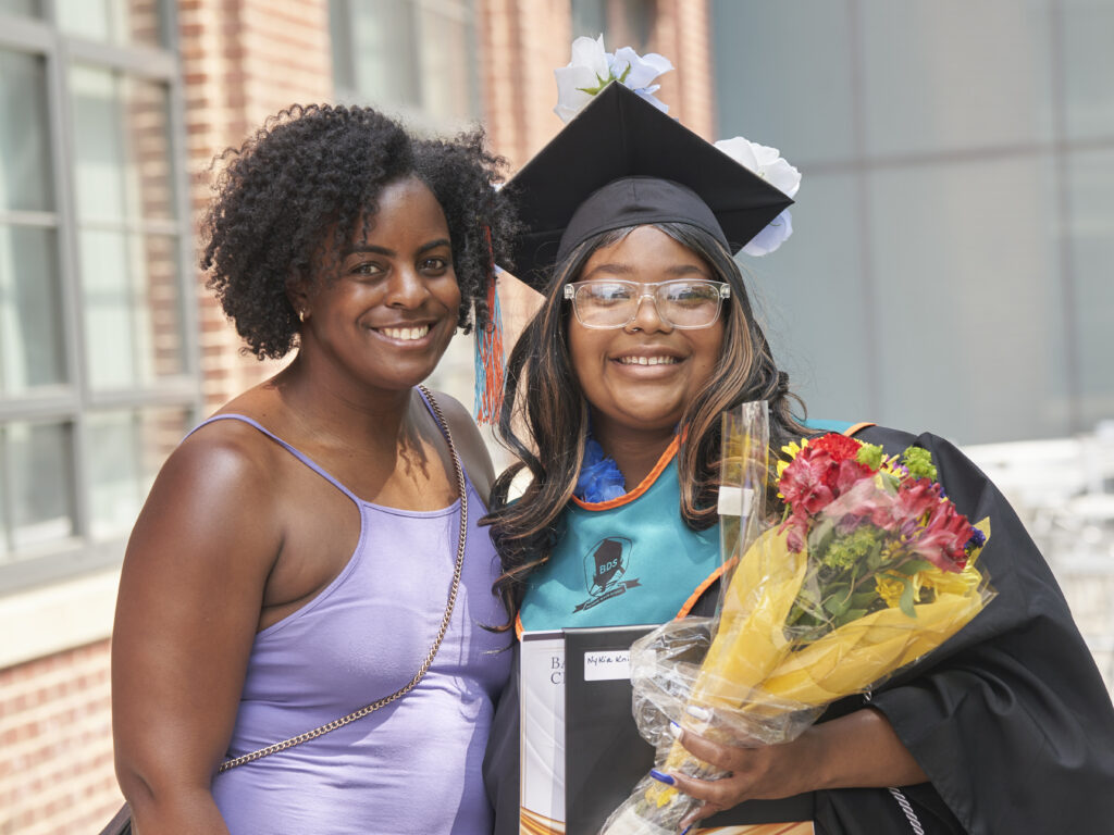 A new graduate poses for a photo with her mentor.